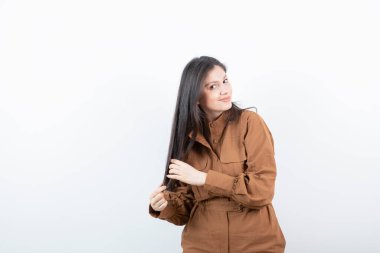 Beyaz duvarda uzun saçlarını gösteren esmer bir kadın modeli. Yüksek kalite fotoğraf