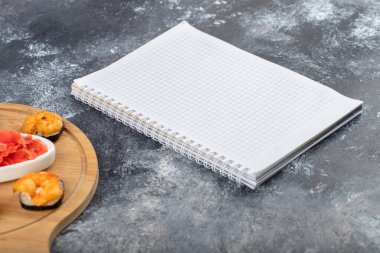 Tahta kesme tahtasına yerleştirilmiş taze, lezzetli suşi ruloları, karides ve zencefil dilimleri. Yüksek kalite fotoğraf