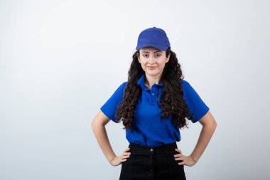 Mavi üniformalı, elleri kalçasında genç bir teslimatçı kadın. Yüksek kalite fotoğraf