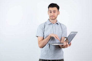 Beyaz duvarın üzerinde dizüstü bilgisayarı olan genç bir öğrencinin portresi. Yüksek kalite fotoğraf