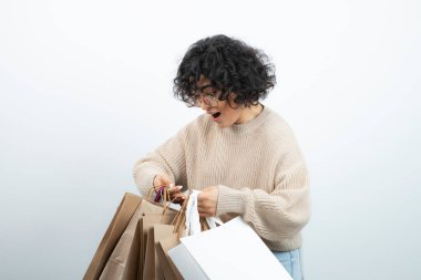 Alışveriş torbalarını beyaz üzerinde taşıyan mutlu bir kadın. Yüksek kalite fotoğraf
