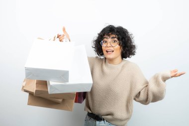 Alışveriş torbalarıyla ayakta poz veren genç bir bayan. Yüksek kalite fotoğraf