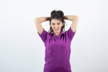 Mor tişörtlü esmer kızın saçıyla oynadığı fotoğraf. Yüksek kalite fotoğraf