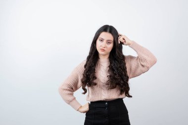 Beyaz duvara karşı duran ve poz veren güzel bir kadın resmi. Yüksek kalite fotoğraf