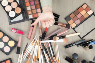 Makyaj malzemelerinin yanında baş parmağını gösteren bir kadın el. Yüksek kalite fotoğraf