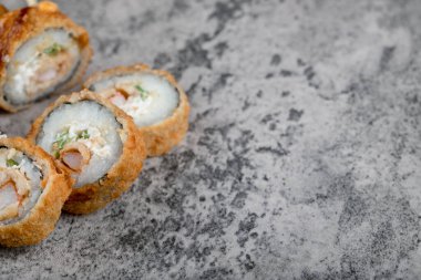 Kayadan bir arka planda sıcak kızarmış suşi ruloları. Yüksek kalite fotoğraf