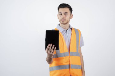 Yelek giymiş, elinde not defteri olan bir inşaat işçisinin fotoğrafı. Yüksek kalite fotoğraf