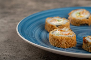 Mavi suşi ruloları bir taş masanın üzerine yerleştirilmiş. Yüksek kalite fotoğraf