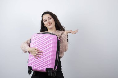 Stüdyo portresi. Elinde pembe bir valiz tutan güzel bir genç kadın. Yüksek kalite fotoğraf