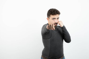 Ayakta duran ve yumruk atan genç bir adamın portresi. Yüksek kalite fotoğraf