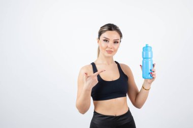 Su şişeli spor elbiseli genç bir kadın.