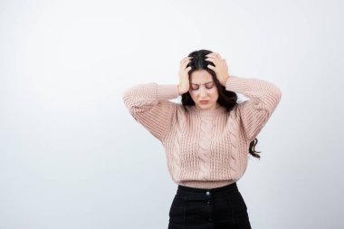 Kafasını beyaz duvara dayamış güzel bir kadın görüntüsü. Yüksek kalite fotoğraf