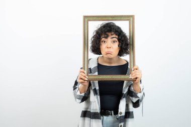 Esmer, güzel bir kadın, elinde eski, ahşap bir çerçeve tutuyor. Yüksek kalite fotoğraf