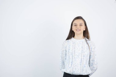 Beyaz arka planda duran süveter giyen kız
