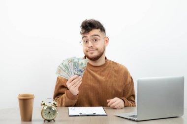 Genç ve mutlu muhasebeci masasında oturup paraları sayıyor. Yüksek kalite fotoğraf
