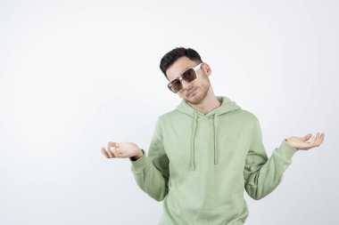 Gözlüklü yakışıklı bir adamın beyazın üzerinde poz verirken görüntüsü. Yüksek kalite fotoğraf