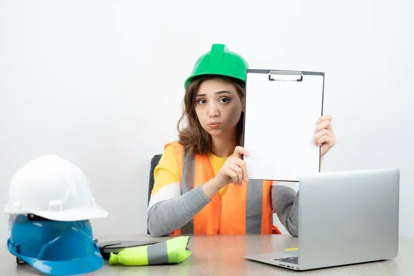 Arbeiterinnen Uniform Sitzen Schreibtisch Mit Laptop Und Klemmbrett Hochwertiges Foto — Stockfoto