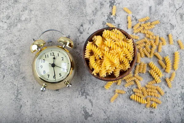 Drewniana Miska Surowego Makaronu Fusilli Zegar Kamiennej Powierzchni Wysokiej Jakości — Zdjęcie stockowe