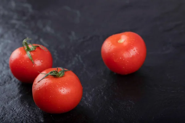 Punainen Tuoreita Tomaatteja Sijoitetaan Mustalla Pohjalla Laadukas Kuva — kuvapankkivalokuva