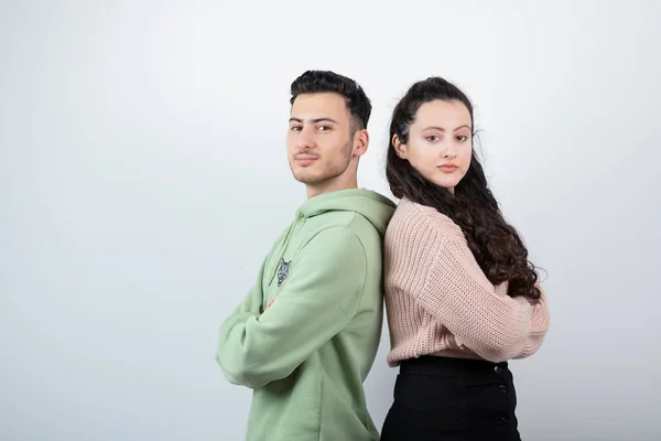 白い壁に腕を組んで立っている若いカップル 高品質の写真 — ストック写真