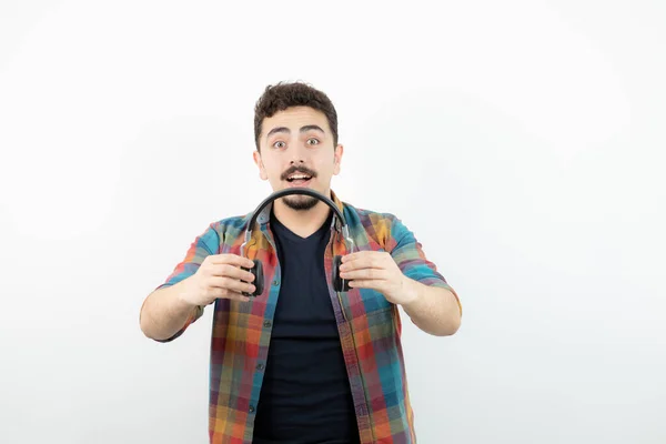 Imagen Joven Guapo Sosteniendo Auriculares Sobre Una Pared Blanca Foto — Foto de Stock