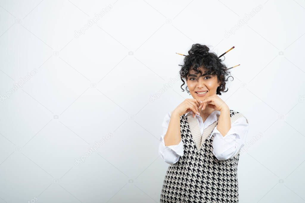 Photo of young woman with messy bun posing to camera. High quality photo