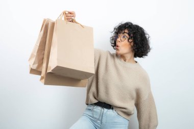 Esmer bir kadının gözlüklü hali. Elinde el işi çantaları var. Yüksek kalite fotoğraf