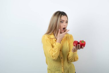 Kırmızı dolmalık biberlere bakan güzel sarışın kadının fotoğrafı. Yüksek kalite fotoğraf