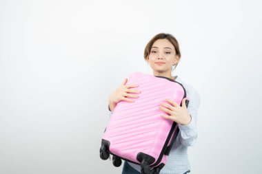 Kadın turist ayakta ve elinde pembe bir valiz tutuyor. Yüksek kalite fotoğraf