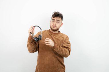 Siyah kulaklık tutan genç bir erkek model. Yüksek kalite fotoğraf