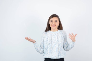 Beyaz arka planda duran süveter giyen kız