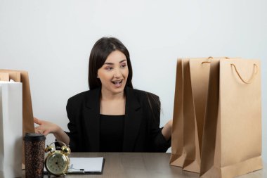 İş kadını iş yerinde elinde dosya ve bir bardak içkiyle oturuyor. Yüksek kaliteli fotoğraf.