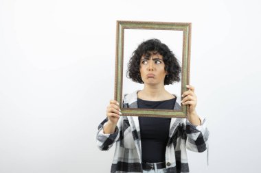 Esmer, güzel bir kadın, elinde eski, ahşap bir çerçeve tutuyor. Yüksek kalite fotoğraf