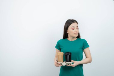 Kahve fincanı ayakta duran mavi tişörtlü güzel bir kadın resmi. Yüksek kalite fotoğraf