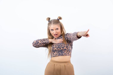 Parmak ucunda duran ve işaret eden sevimli genç kadın modelinin portresi. Yüksek kalite fotoğraf