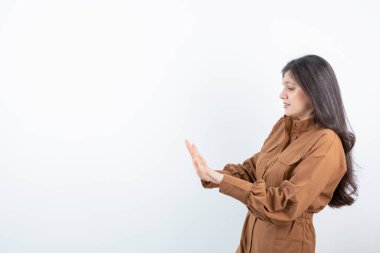 Beyaz duvarda dur işareti yapan sevimli bir kadın modeli resmi. Yüksek kalite fotoğraf