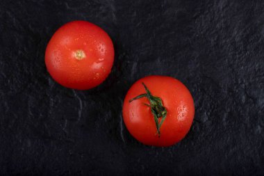 Siyah arka plana yerleştirilmiş kırmızı taze domatesler. Yüksek kalite fotoğraf