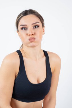 Siyah ekin giymiş, ayakta duran ve nefesini tutan formda genç bir kadın görüntüsü. Yüksek kalite fotoğraf