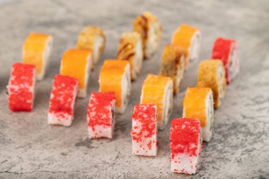 Taş zeminde bir sürü karışık lezzetli suşi rulosu. Yüksek kalite fotoğraf