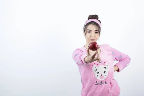 Foto Uma Jovem Pijama Mostrando Uma Fruta Maçã Vermelha Para — Fotografia de Stock