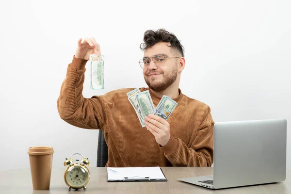 若い男性会計士が机に座って現金を見せている 高品質の写真 — ストック写真