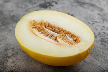 Taş zemine yarım dilimlenmiş sarı kavun yerleştirilmiş. Yüksek kalite fotoğraf