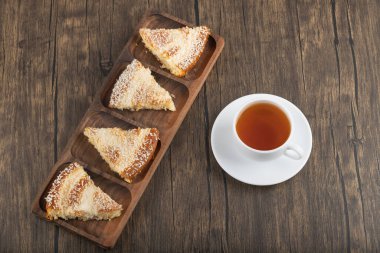 Hindistan cevizi dilimli tatlı dilimleri ve ahşap masaya konmuş bir fincan çay. Yüksek kalite fotoğraf