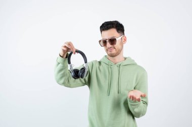 Gözlüklü yakışıklı bir adam kulaklığa bakıyor. Yüksek kalite fotoğraf