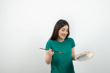 Renkli fırça ve palet kullanan genç, güzel bir sanatçı. Yüksek kalite fotoğraf