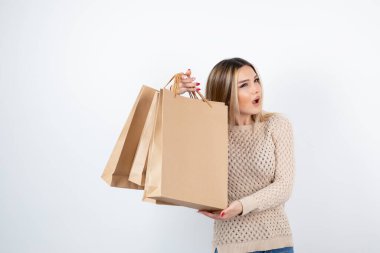 Elinde kağıt torbalarla ayakta duran güzel bir kadın resmi. Yüksek kalite fotoğraf