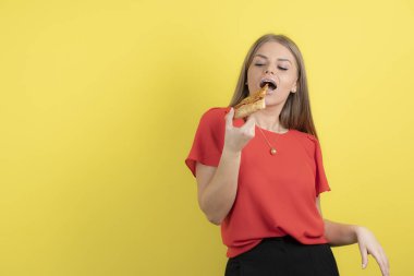 Lezzetli bir dilim pizza yiyen çekici bir kadın görüntüsü. Yüksek kalite fotoğraf