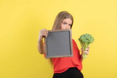 Sağlıklı brokoliyle çerçevesini tutan güzel bir kadın modeli. Yüksek kalite fotoğraf