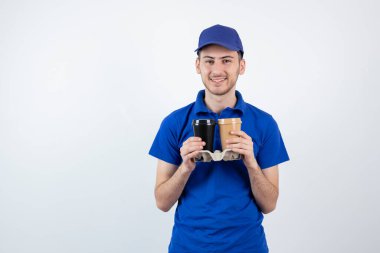 Mavi üniformalı genç yakışıklı kahve siparişi veriyor. Yüksek kalite fotoğraf