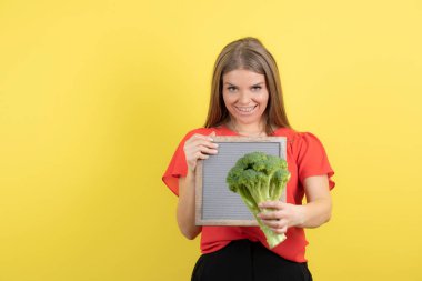 Sağlıklı brokoliyle çerçevesini tutan güzel bir kadın modeli. Yüksek kalite fotoğraf